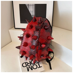 Detail of red and black crocodile textured backpack with punk style spikes and straps
