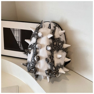 Close-up of black and white snakeskin backpack with 3D white punk cone studs and rivets