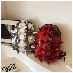 Detail view of spiked crocodile pattern backpacks with gradient red and white finishes