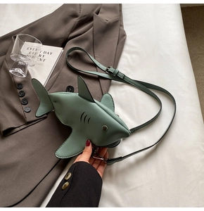 Detail of shark-shaped crossbody bag showing stitching and fin details on light green PU leather