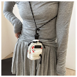 Mini cherry print canvas pouch detail showing zipper and woven crossbody lanyard strap