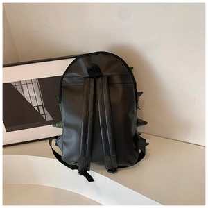Detail view of the black backpack with green scale fins and adjustable shoulder straps