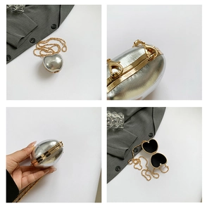 Detail showing the heart-shaped silver hard shell bag with golden chain and black lining