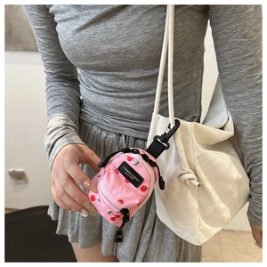 Pink mini cherry print backpack charm with black clip attachment and zipper detail