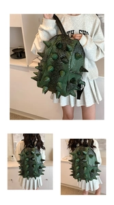 Detail view of dark green backpack featuring bold 3D conical spikes and croc texture