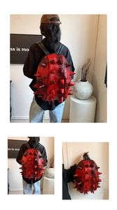 Macro shot of red faux crocodile leather backpack with punk style metal spike studs