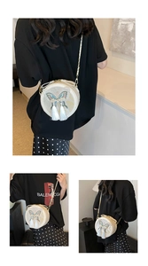 Vue détaillée de la broderie papillon et du pompon sur le sac à bandoulière rond