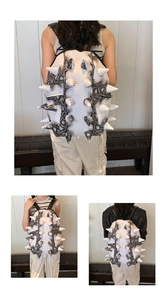 Detail view of white backpack with large 3D spikes and exotic snakeskin texture