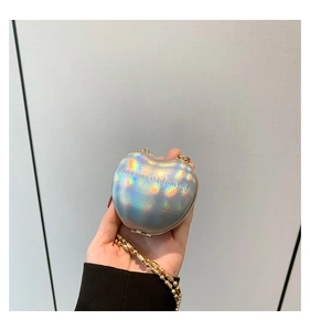 Macro detail of heart-shaped laser leather mini bag with golden bead chain handle