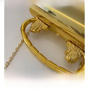 Detailed macro view of the gold mirror acrylic bag featuring an ornate metal relief handle