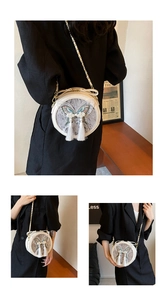 Détails d'un sac bandoulière rond avec broderie papillon, perles et glands