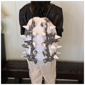 Detail of white backpack featuring large 3D spikes and exotic snakeskin texture