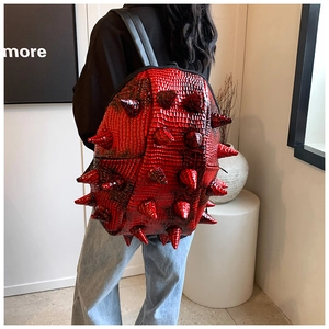 Detail of red punk backpack with hedgehog spikes and crocodile texture on model