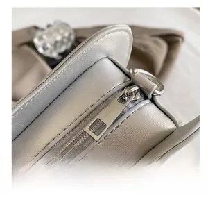 Macro shot of smooth metal zipper detail on silver gray vintage star shoulder bag