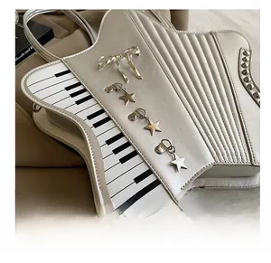 Detail showing white piano-inspired bag with keyboard print and metal star pendants