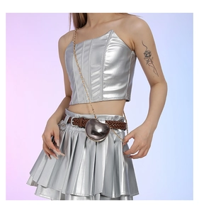 Detail of silver metallic bandeau top and pleated skirt with a heart chain bag
