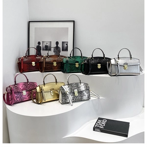 Macro display of multiple snakeskin textured tote bags with metallic gold twist locks