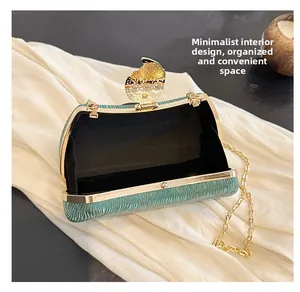 Macro view of green glitter box bag interior with gold leaf clasp and chain strap