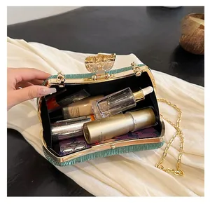 Detail of dark green evening bag interior showing capacity for makeup and accessories