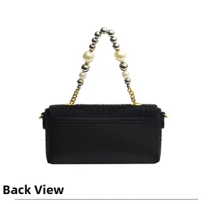 Back view of black pebble leather clutch featuring rhinestone flap and pearl handle