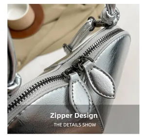 Detail view of smooth silver metallic leather texture and premium double zipper closure