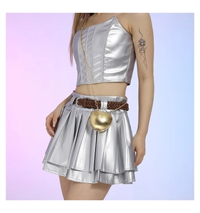 Detail of silver metallic Y2K crop top and pleated skirt with gold heart chain bag