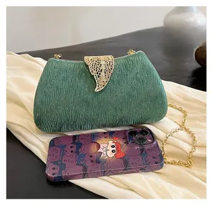 Detailed size comparison of green glitter evening clutch with golden leaf clasp