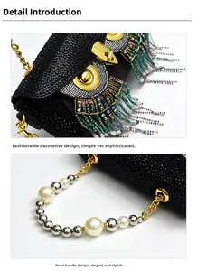 Detail of owl clutch with black rhinestones, golden hardware, and pearl strap