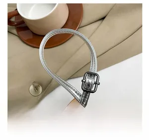 Macro detail of adjustable silver metallic strap buckle on heart-shaped shoulder bag