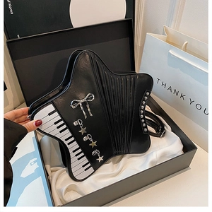 Detail of star-shaped crossbody bag with piano key patterns and silver bow pendant