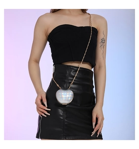 Mini holographic apple-shaped crossbody bag with gold chain strap shown on model