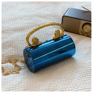 Close-up of blue metallic cylindrical clutch bag with ornate lion head gold handle
