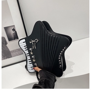 Detail of star-shaped crossbody bag featuring piano keys and accordion pleated design