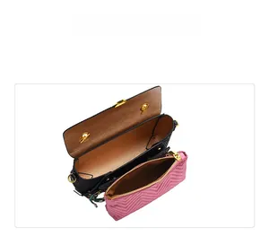 Interior view of black owl crossbody bag with pink quilted pouch and brown lining