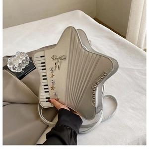 Macro detail of silver star-shaped piano bag with accordion folds and metallic charms