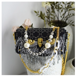 Detail of owl-shaped bag featuring pearl eyes, rivet studs, and crystal fringe