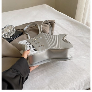 Detail of silver star shaped bag with piano key patterns and metallic stud accents