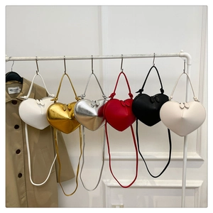 Detail view of heart-shaped crossbody bags in glossy metallic and matte finishes