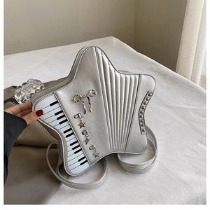 Detail view of silver star-shaped bag featuring piano keys and metallic bow charm