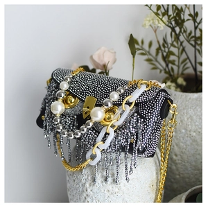 Detail of luxury owl evening bag featuring silver rhinestones, pearls and crystal tassels