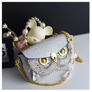 Detail view of owl evening bag featuring silver rhinestones and beaded tassels