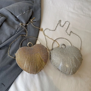 Sparkling heart-shaped clutch bags in gold and silver with rhinestone tassels and chain