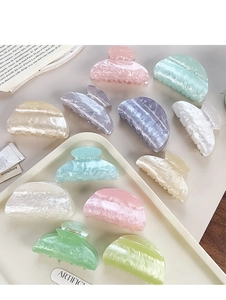 Detailed view of large marble texture acetate hair claws in various pastel macaron colors