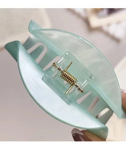 Detailed close-up of mint green marble pattern hair claw clip with golden metal spring