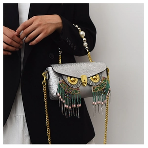 Detail of owl clutch with sequin finish, pearl handle and colorful beaded fringe