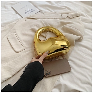 Dettaglio di una borsa da sera dorata a forma di fagiolo con finitura a specchio e catena