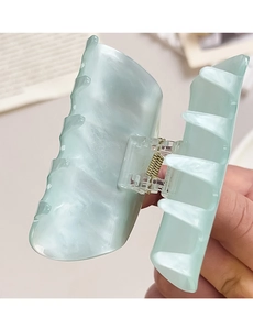 Detail showing marble texture and golden metal spring of the mint green hair claw clip