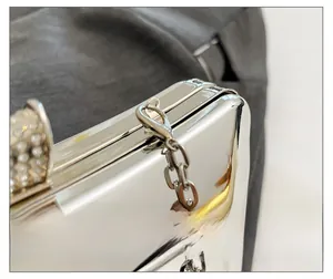 Makroaufnahme der silbernen Abendtasche mit Strass-Schnalle und Kettendetails