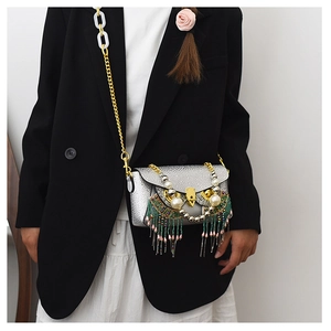 Silver owl crossbody bag featuring pearl eyes and colorful tassels on a stylish model