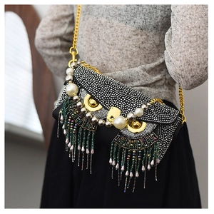 Detail of the owl-shaped bag featuring colorful bead tassels and luxury pearl accents